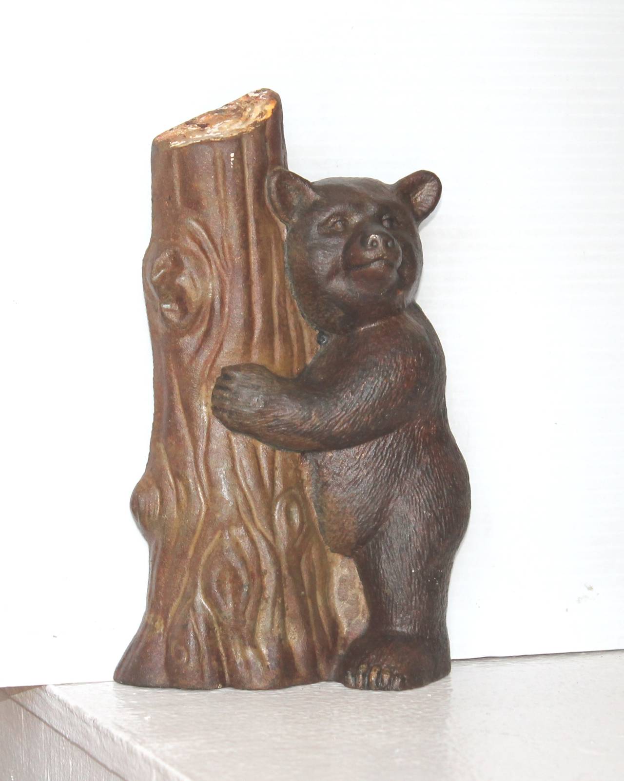 This 19th century original painted cast iron bear hugging the tree. Maybe she was getting ready to climb up the tree. The painted surface is the best. The condition is very good.