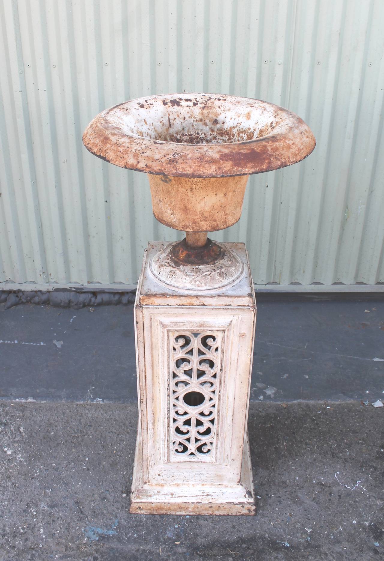 This early original white painted 19th century iron urn has a wonderful wide top form shape. It sits on the original painted iron plinth. This is most unusual this tall original painted base. They are a perfect set in great condition. Fantastic
