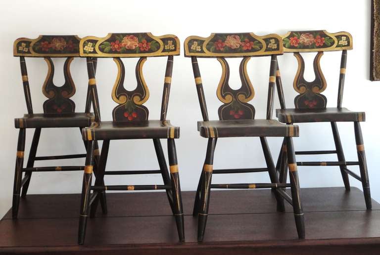 Early and all original colorful 19thc decorated plank bottom chairs from Lancaster County ,Pennsylvania .The untouched remarkable painted surface and form is the very best.These lire cut out backs are also heavily  decorated along with the seat back