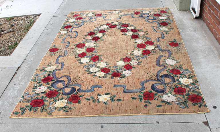 This large room sized hand-hooked floral rug was created in the tradition of master rug designer, Pearl McGown. This rug is in particularly outstanding condition for its age as there is no fraying or damage of any kind. The beige background is