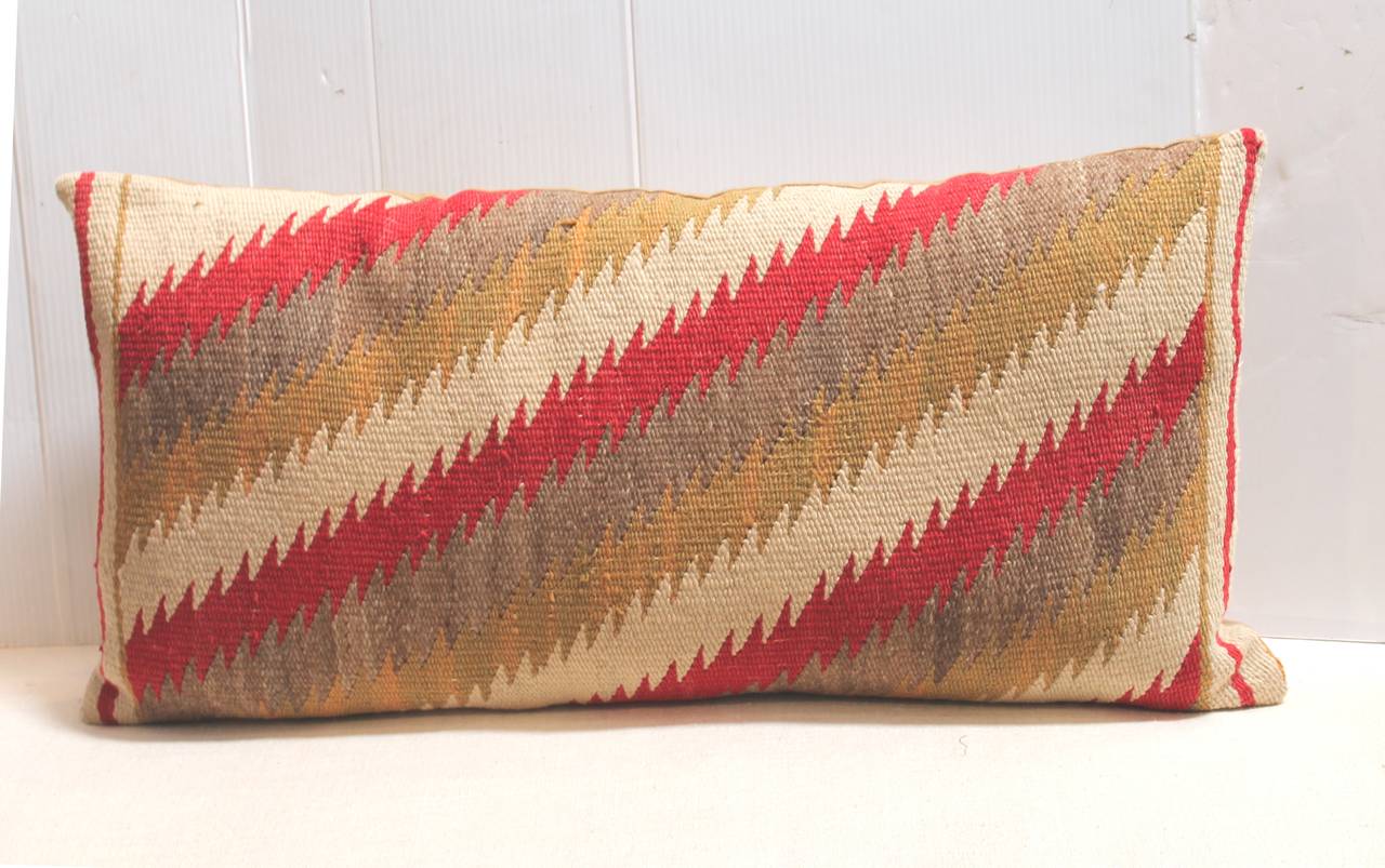 This early geometric Navajo weaving pillow has a wonderful jagged edge pattern almost like feather edge streak of lightning pattern. The backing is in a tan cotton linen.