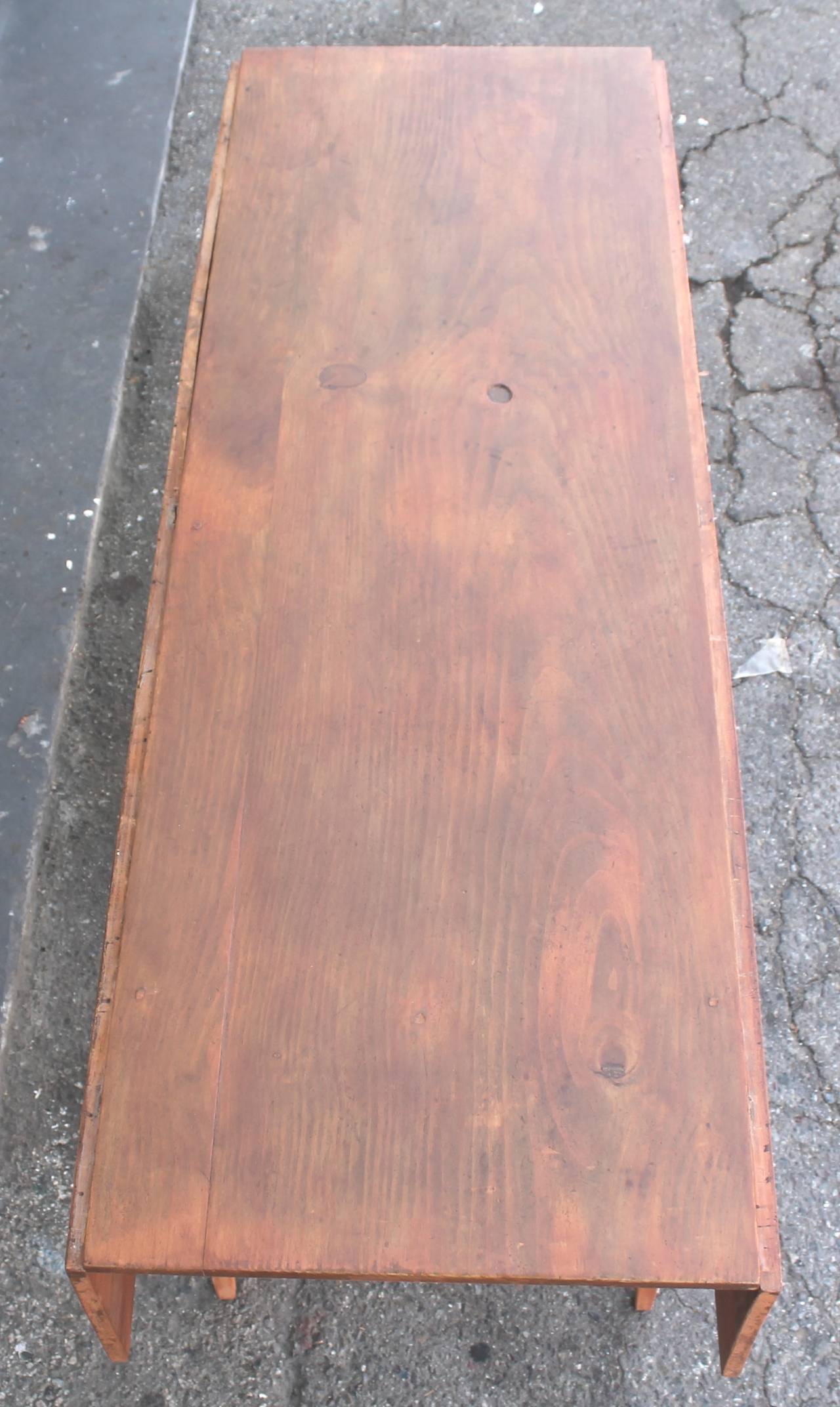 This finely constructed early 19th century pine original salmon painted base with a scrub top farm table also has drop leaf ends. It's a great table that seats six to eight people comfortably. This New England harvest or farm table also would make a
