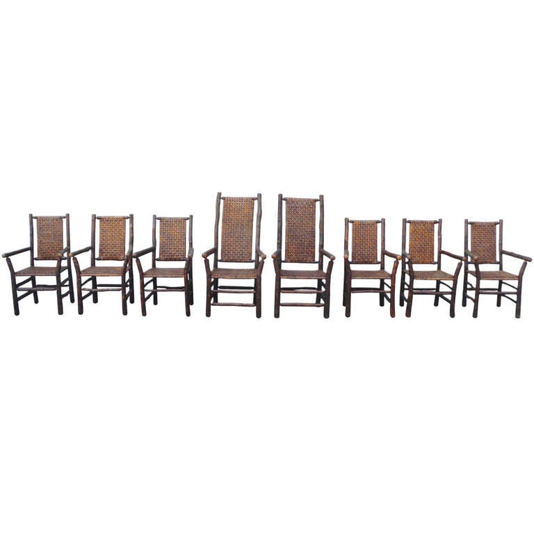 This is a complete and rare set of eight signed Old Hickory, Martinsville, Indiana arm chairs. This set of dining chairs is all in pristine condition and have all original handwoven seat and backs. The surface on these chairs are amazing .They are