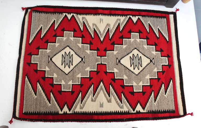 Classically Ganado in style, this Navajo Indian Woven Saddle Blanket dates to the mid-1930’s and shows a pallet of black, white, gray, red and cream with two central diamond patterns upon which the design theme is based.  The edges of the central
