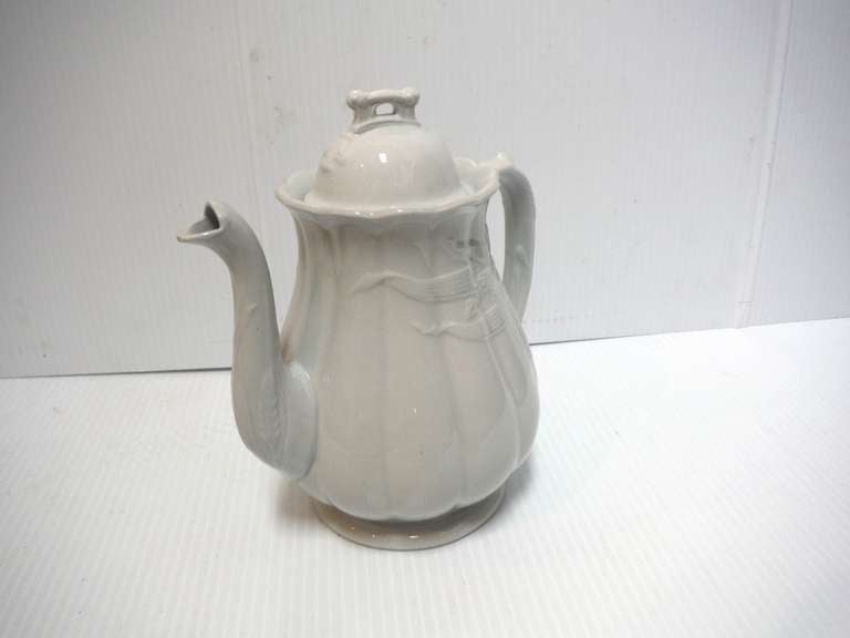 This early English antique ironstone coffee pot made by W & E Corn, Burslem dates from the period between 1864-1891. The relief pattern features sheaves of wheat to either side of the handle and spout. 

This piece measures 9 1/2 inches from