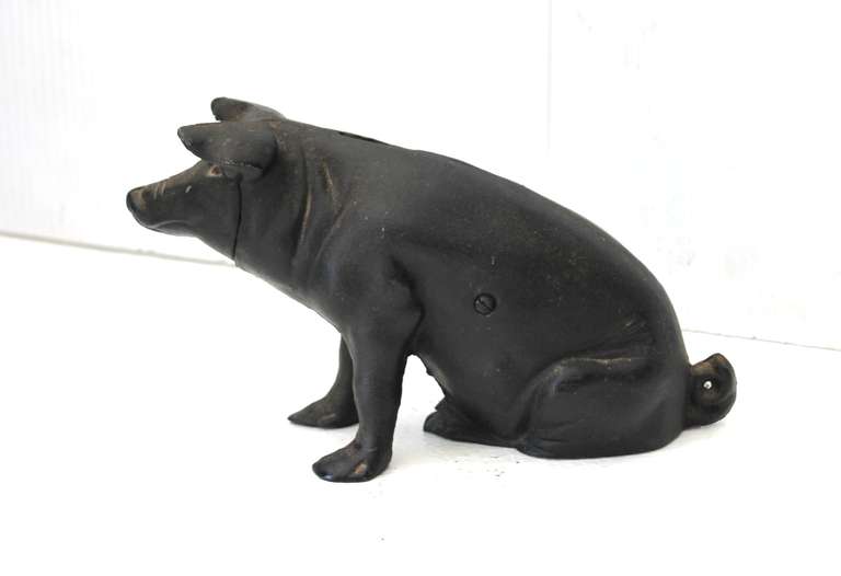 This heavy cast iron pig penny bank was found in New England. It is in as found condition with a light worn coat of black paint. The patina is very nice and smooth. Condition is very good and in operable condition.