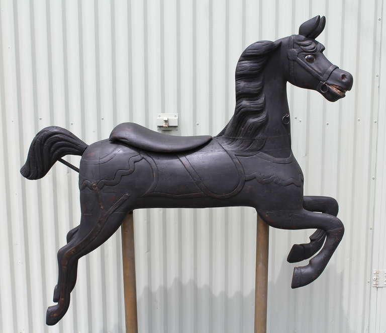 This 19th century wooden Armitage-Herschell track machine carousel horse was originally carved in Tonawanda, New York and dates to the late 1890’s.  With a secondary coat of black paint and its original glass eyes, this horse was fashioned in the
