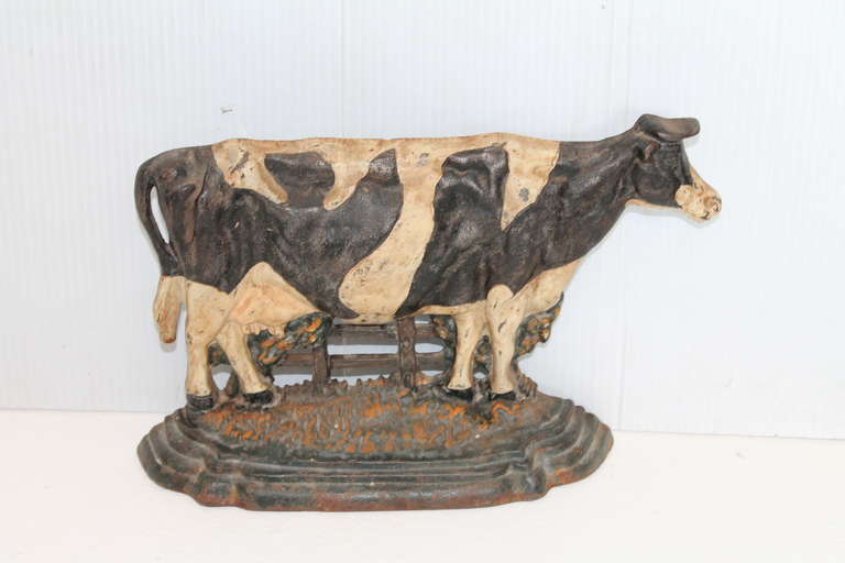 This folky painted iron cow doorstop was found in Pennsylvania and has a wonderful slightly worn surface. The base  has slight paint loss or wear consistent with age. This doorstop is in great condition and looks great on a shelf or on a floor.