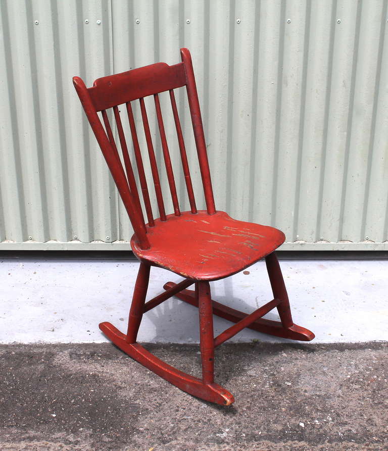 This fantastic 19thc original painted  salmon children's rocking chair is from New England and is in great condition. The seat is a saddle seat form. Minor paint loss to the seat.