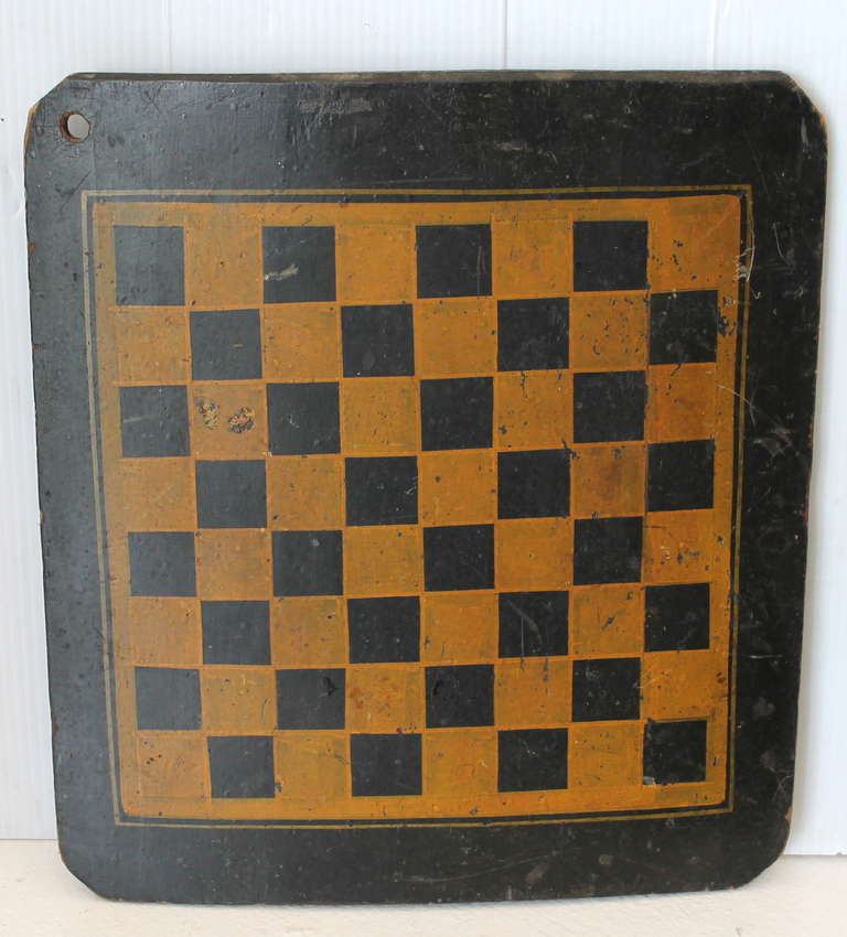 Ce plateau de jeu de dames peint d'origine, datant du 19e siècle, présente une surface en bois peint d'origine polychrome exceptionnelle et est construit à partir d'une seule planche de pin large et légèrement courbée. Le terrain de jeu est peint en