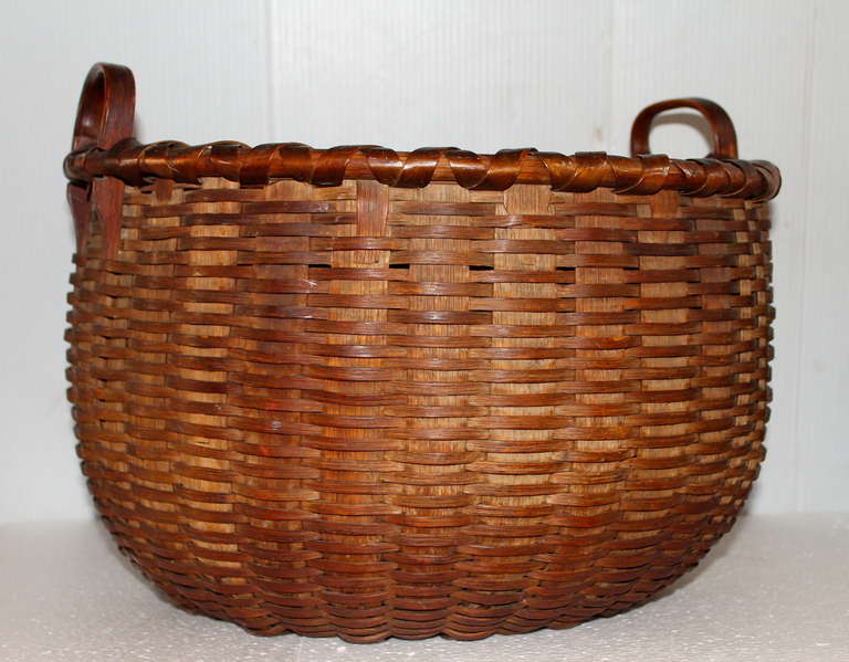 This very large double handled 19thc gathering basket is in pristine condition. It comes from a very important Americana collection in Pennsylvania. The basket is made from split oak and pine woods. The inside has a fantastic kick up bottom. This