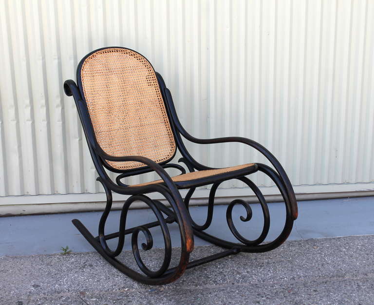 This Thonet rocking chair is signed on the back rung of the rocker. It is in great as found condition with a ebonized surface paint. The condition is very good and sturdy. This special find is very comfortable.