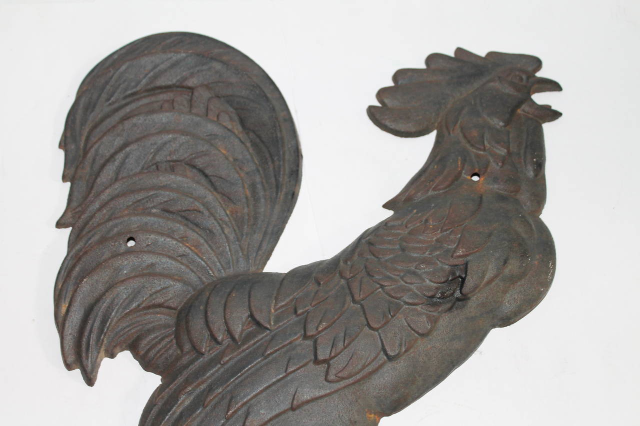 This fantastic Folk Art rooster is in great condition and has holes for mounting or hanging on a wall. This big cock is in fantastic condition and is quite heavy. The feet have fragments of paint. It looks like Rochester iron works of New York but