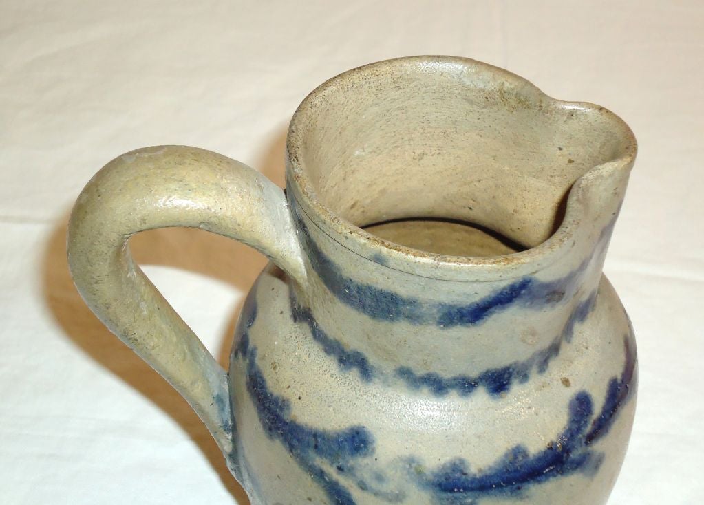 19THC EARLY & RARE FORM AND SIZE PENNSYLVANIA DECORATED STONEWARE PITCHER.THIS HIGHLY DECORATED STONEWARE PITCHER IS FROM CENTRAL PENNSYLVANIA.IT IS MOST UNIQUE BECAUSE OF ITS SMALL SCALE SIZE AND WONDERFUL DECORATION.THE BASE HAS SMALL HAIRLINES