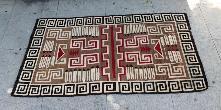 This is a very special weaving / rug with interesting arrows & feathers with in the design. The Greek key border is through out on all four borders in a black and cream color. The inset colors are a tan ground with burg, cream & black colors. This