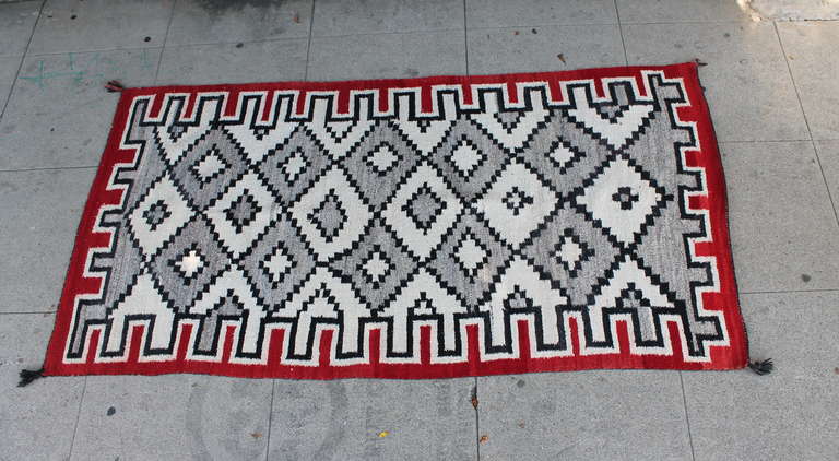 This geometric eye dazzler & hand woven Navajo weaving runner is in very good condition and has the original corner ties. It is very clean with minor lighting in spots. It does not detract from the design nor the condition of this rug. The border is