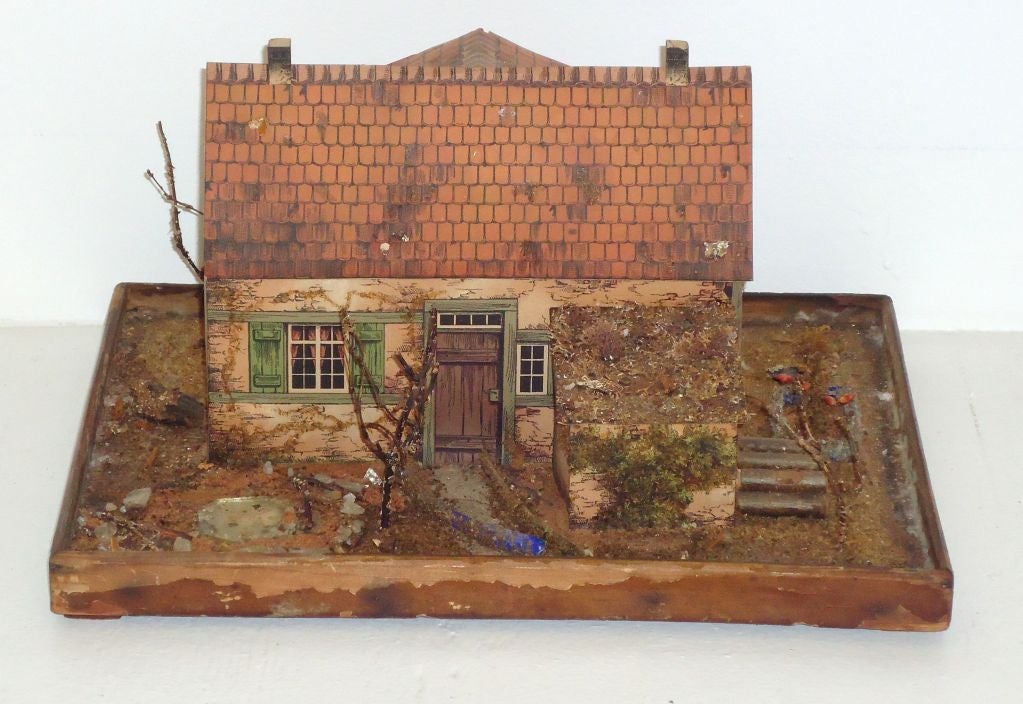 FOLKY AND VERY UNUSUAL ALL ORIGINAL LITHO PRINTED HOUSE OF PAPER AND WOOD CONSTRUCTION.THIS HOUSE HAS BEEN PRESERVED AND IS IN AMASING CONDITION ,IT HAS A GLASS CASE.THE ENTIRE FOLKY HOUSE IS UNDER GLASS.IT HAS BEEN IN A COLLECTION IN THE GLASS BOX