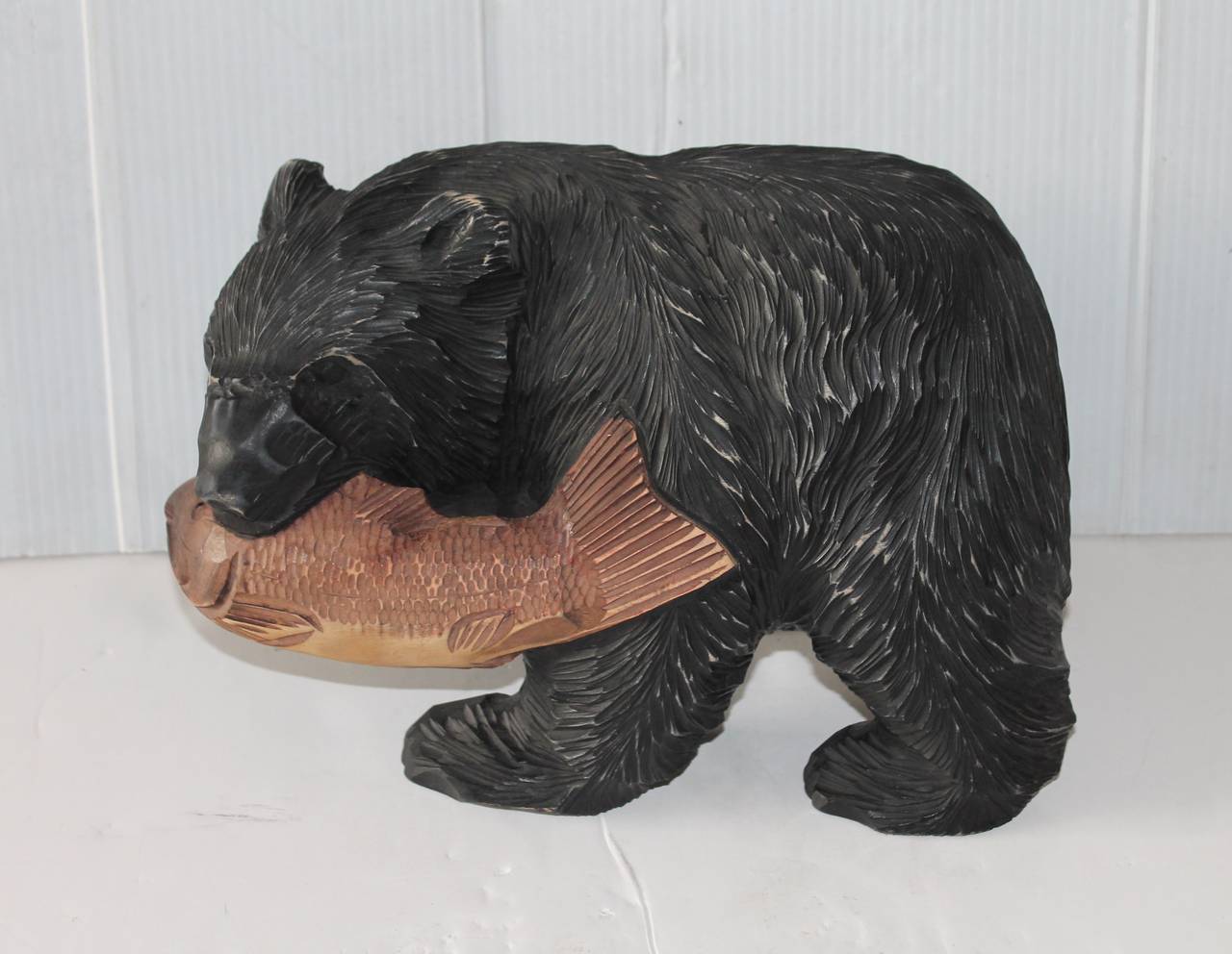 This hand-carved black bear with a fish in its mouth is in wonderful condition with wear consistent with age. We have had these bears in the past that were unpainted and this makes this one a little more unique. It is unsigned.