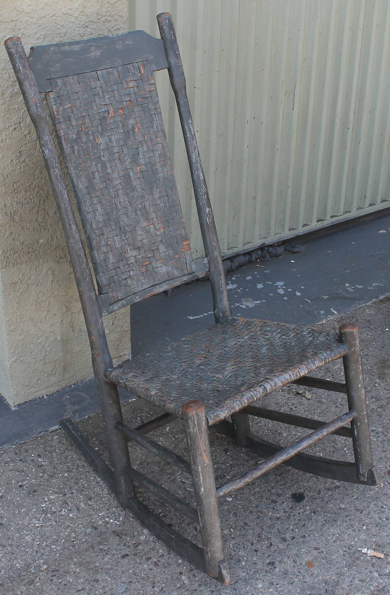 This very early 19th century original grey painted rocking chair is from New England and has the original woven seat and back. This chair is in great condition and most wonderful untouched surface. Super patina.