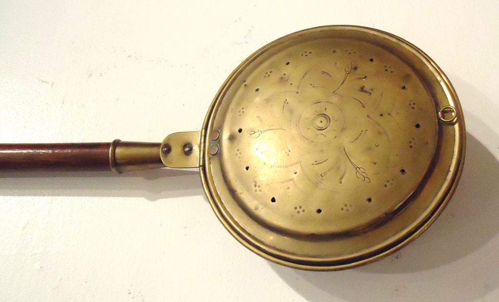 EARLY 19THC BRASS WITH WOOD HANDLED BED WARMER.EMBOSSED PATTERN ON THE BRASS AND ORIGINAL HOLES FOR THE HEAT TO ESCAPE.THE BRASS HAS A WONDERFUL MELLOW PATINA INSIDE AND OUT.THE EARLY BED WARMERS ARE QUITE HARD TO FIND IN SUCH GREAT CONDITION.SO