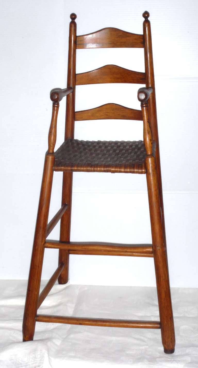 Questa sedia ad altezza d'uomo in legno di hickory e pino dell'inizio del XIX secolo, piuttosto rara, proviene dal New England. Lo stile è simile a quello degli Shaker, con una forma fantastica e un'apertura a ventaglio. Il sedile è probabilmente un