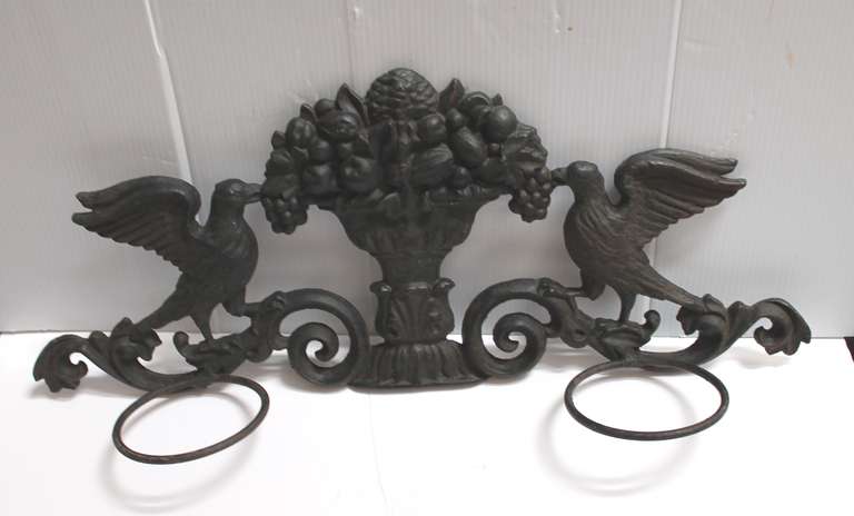 This is such a unbelievable planter with a urn filled with fruit and a dove on each side. The surface is a wonderful aged black painted iron with standard size  pot holder holes. A pair of white  pottery pots that fit perfectly are included. This is