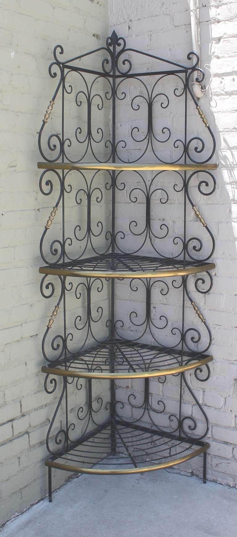 This is quite unusual early 20th century bakers bread rack. It is made of brass trim and iron base along with ornate brass trims. It is very sturdy and would fit nicely in any corner.The condition is very good and sturdy,