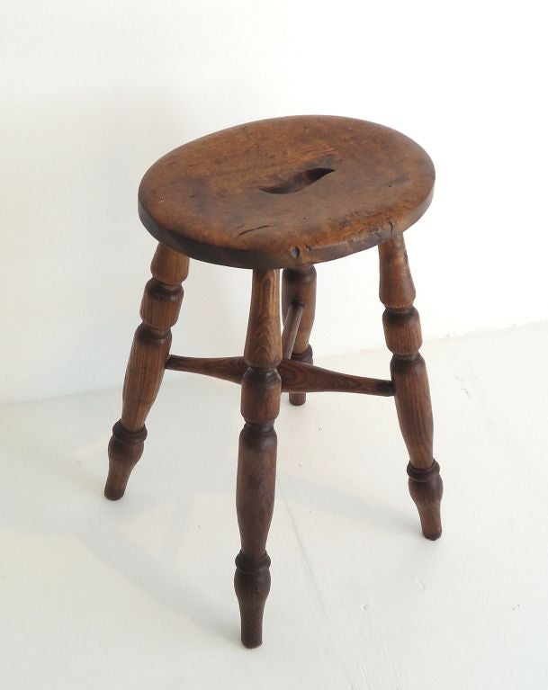 Early 19th century walnut stool from New England with the original finger hole in top. The condition is very good and has a wonderful mellow patina.
  