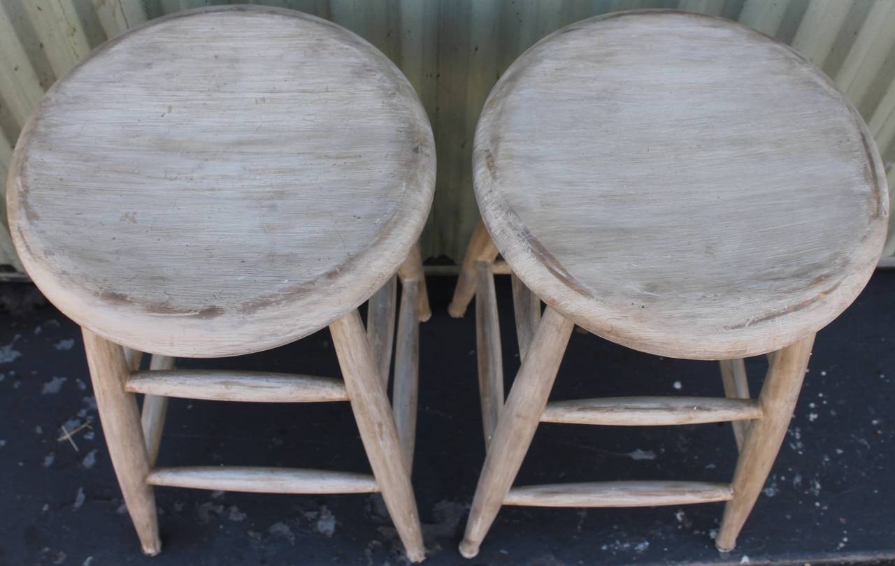 These sturdy stools are in great condition and very sturdy. They are over painted with an original white painted base coat. The surface is distressed and worn consistent from age and use. Sold as a pair only.