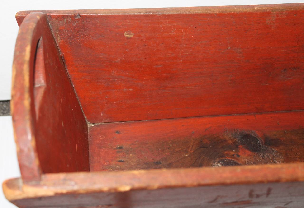 This fancy 19th century original brick red painted handmade child's doll cradle has all original cut-out and fancy cut-out rockers. The condition is very good with early cut nail construction. The patina is the very best.
