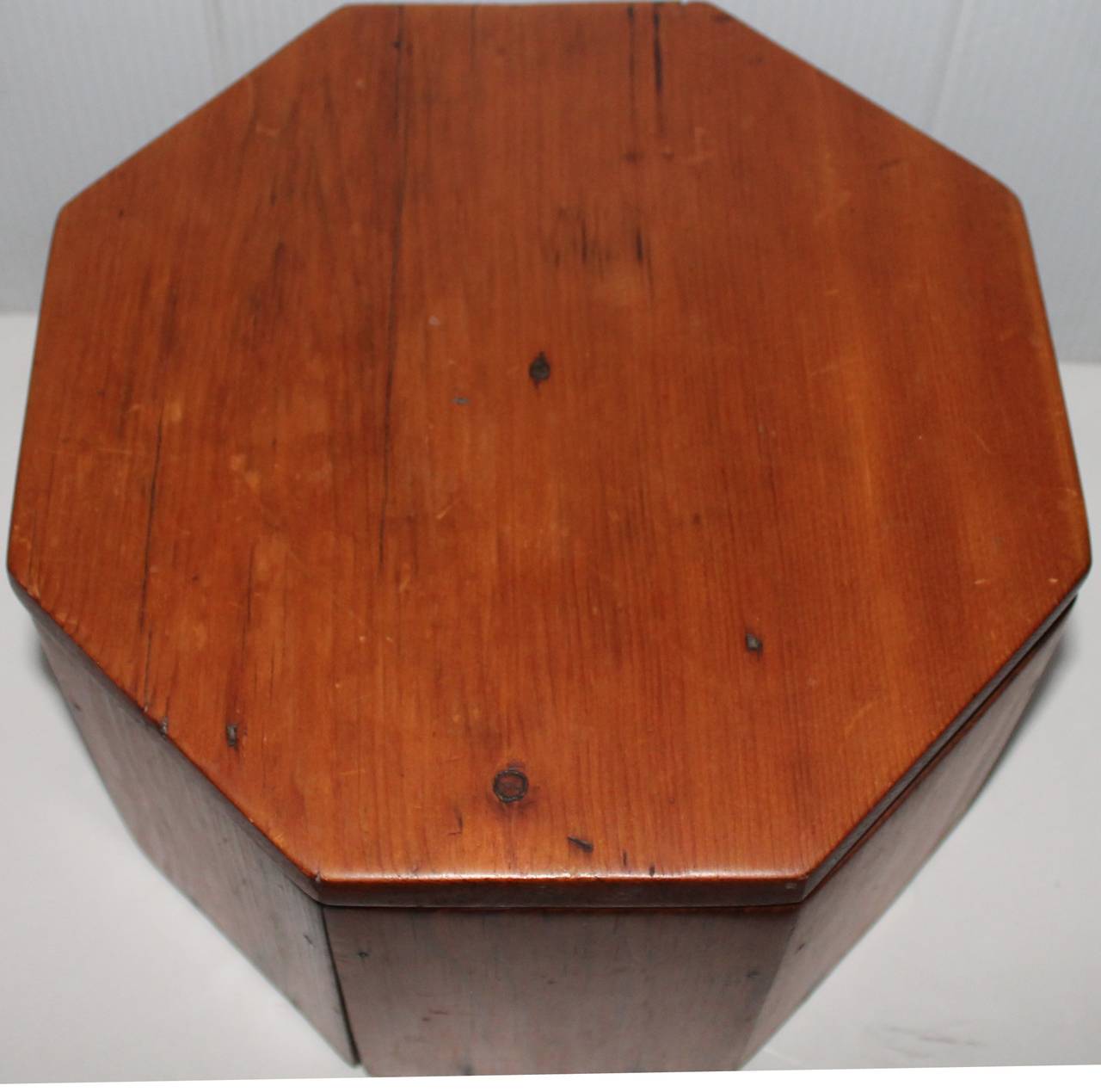 This eight-sided pine storage box is 19th century and in great as found condition. It has four pieces of wood and possibly had wood casters at one time. The only thing that was added at one time was a metal chain to hold it open or closed. The