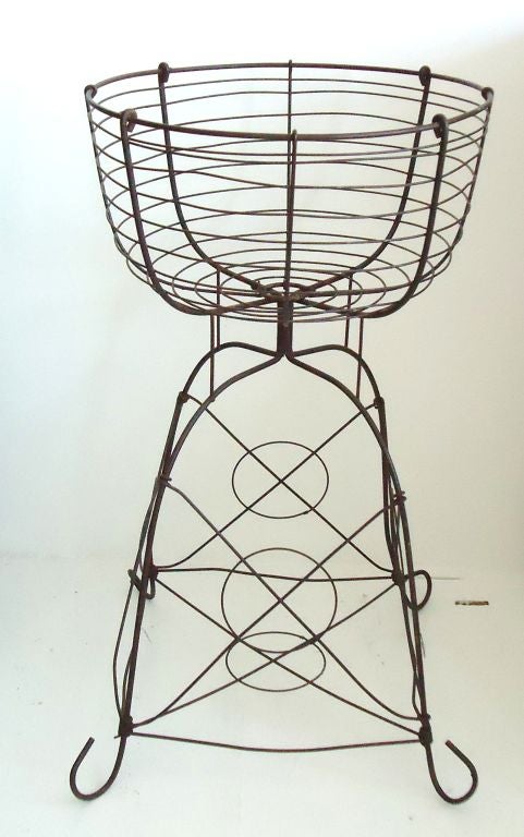 FOLKY AND COOL EARLY 20THC WIRE BASKET ON FEET . GREAT AS A  PLANTER OR OLG GENERAL STORE DISPLAY.