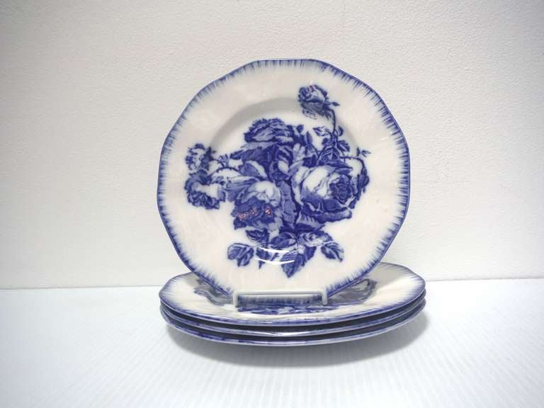 These four flow blue ironstone plates were the design inspiration of the Gloire de Dijon rose, an old favorite found in English cottage gardens. In addition to the deeply saturated cobalt blue cabbage rose florals and decorative edging, the plates