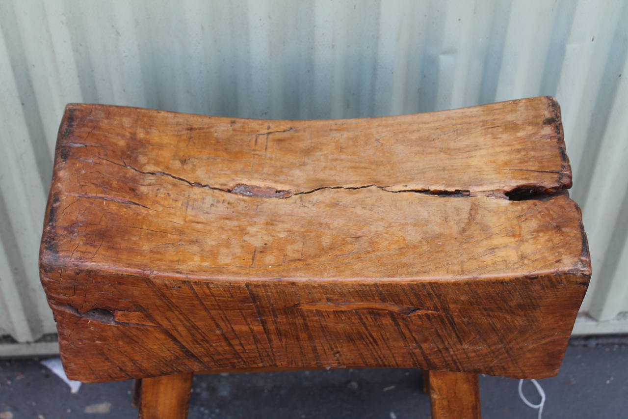 19th century thick and butcher block plank seat. Very strong sturdy stool. The plank is curved for comfort. This bench is cool as a side table or a stool to sit on like as in a kitchen.