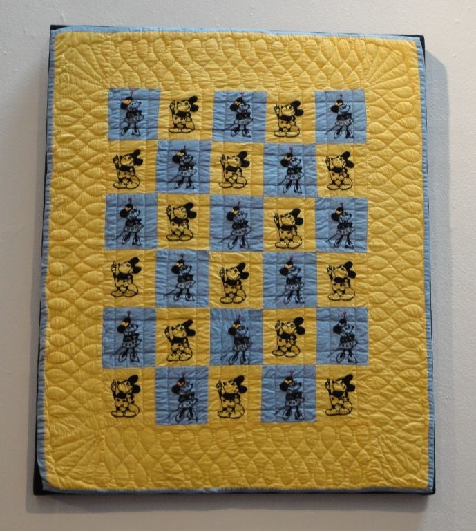 This crib quilt is all hand embroidered Mickey and Minnie Mouse. The embroidery is very well done and the quilting is very good too. The backing on this quilt is blue like the binding. The condition is very good and it is mounted on black linen on a