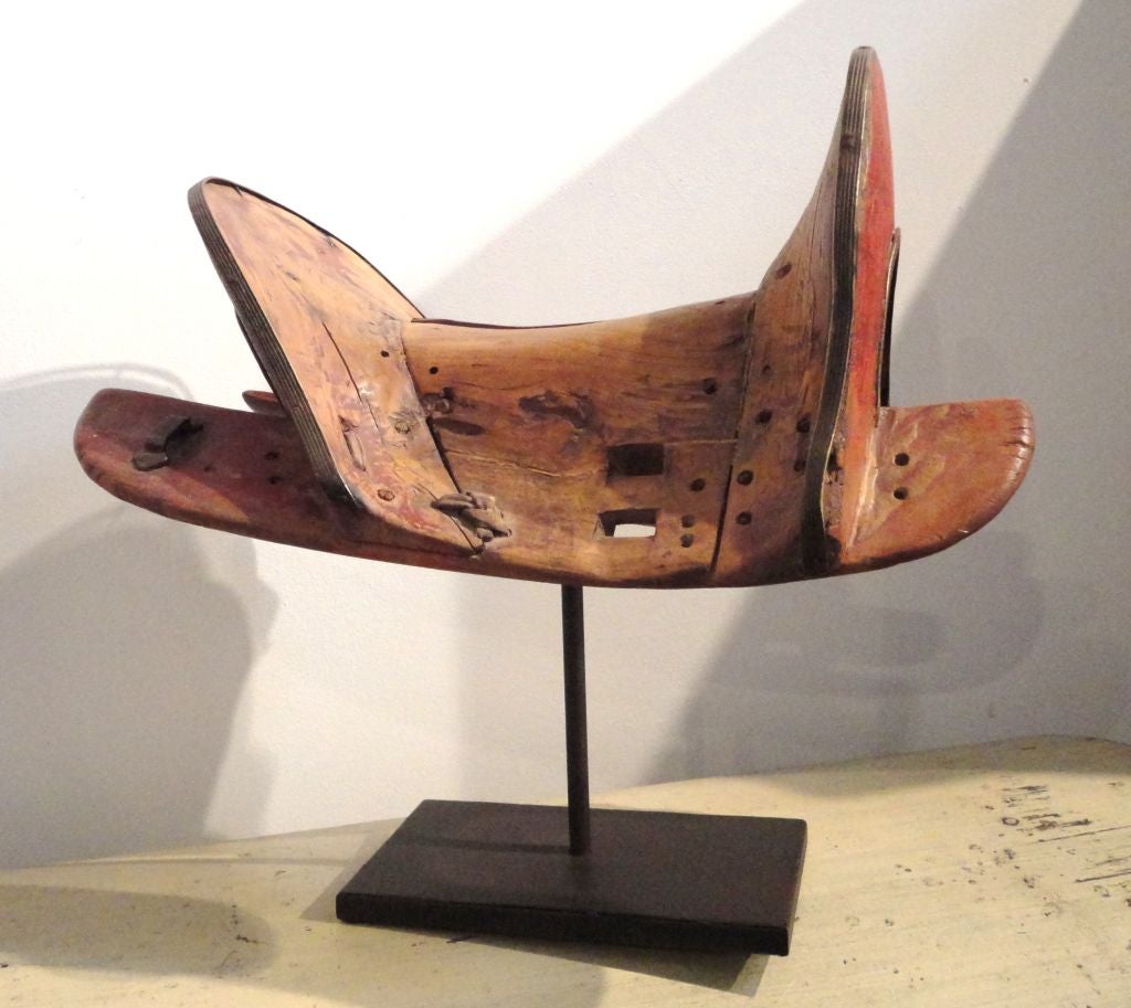 EARLY AND QUITE UNUSUAL HANDMADE ORIGINAL WORN RUST PAINTED SADDLE HOLDER.FANTASTIC WORN PATINA AND RAWHIDE TIES AND TRIMED IN ORIGINAL BRASS WELTING.WONDERFUL ORIGINAL PEG CONSTRUCTION.THIS IS FROM A PRIVATE WESTERN COLLECTION FROM THE NORTH WEST