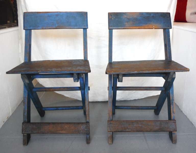 Wow this pair of electric dry blue painted folding or camp chairs have the most amazing patina and surface . The interesting construction and form is the best . They are very comfortable and sturdy . Sold as a pair .These chairs were found in the