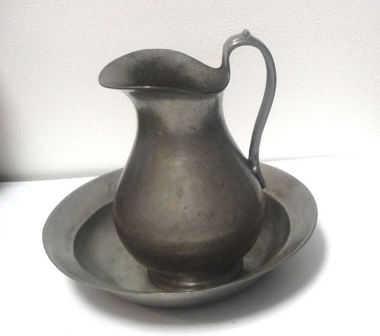 These two 18th century pieces are quite rare and in amazing condition. The two pieces are hall marked and the pitcher is dated 1760 and the bowl is marked 1778 .The two pieces are good English pewter. The pitcher has the best form. Sold as a group