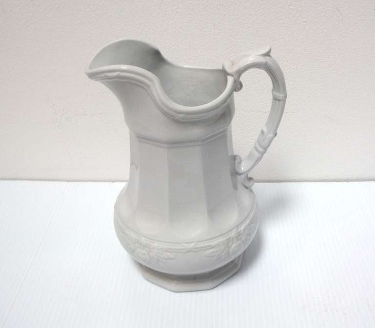 This 19th century English white ironstone pitcher/ ewer have a distinctive shape with an embossed fig leaf pattern banding the lower portion of the pitcher. This piece is in excellent antique condition with no cracks or chips, there is some crazing.