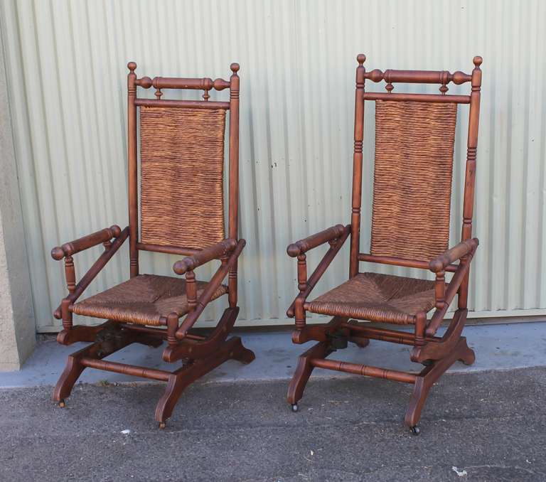 This pair of super comfortable 19thc  platform rockers have been rewoven seats and backs in a fantastic rustic straw . They are durable and very sturdy pine wood with a dark old surface. The pair would work indoors or on a covered porch or