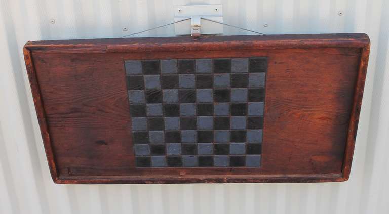 This 19th century blue and grey painted game board has a natural worn patina border and back board. It is square nailed construction and in great condition. Minor wear consistent with age and use. This is a very early game board.