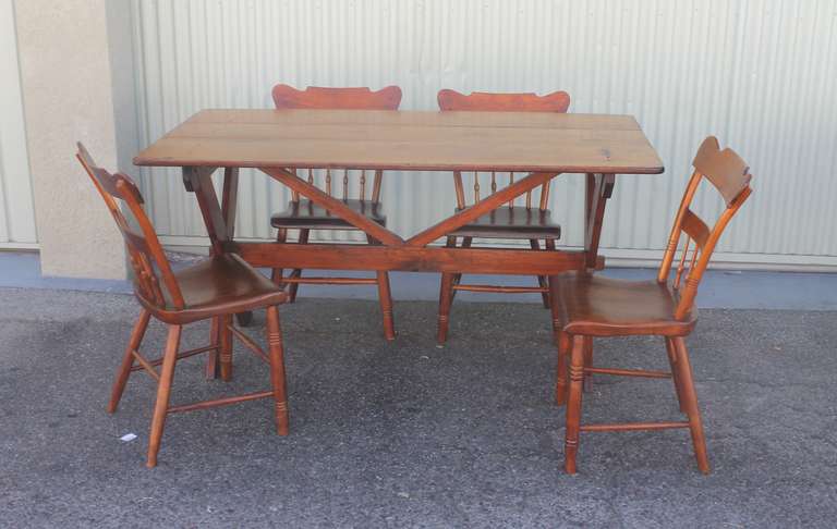 This early 19th century three board top sawbuck table is from Pennsylvania.The condition is very good and sturdy with a wonderful untouched surface. This table and four 19th century pine plank bottom chairs came from the same collection. The chairs