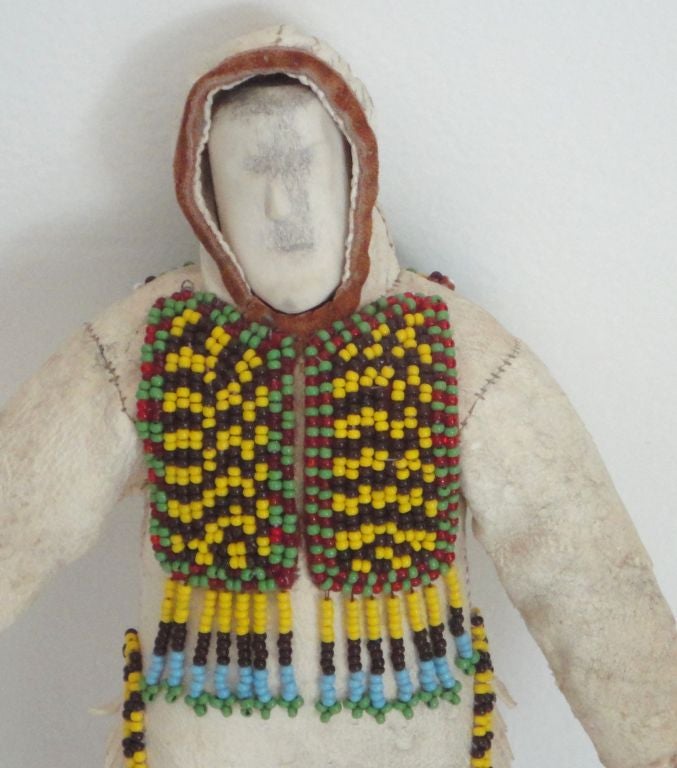 FANTASTIC ALL ORIGINAL BEADED AND HIDE CLOTHING ON THIS ESKIMO DOLL.HAND CARVED BONE HEAD WITH A FACE CARVED OUT.THIS DOLL IS FROM A PRIVATE COLLECTOR AND IS IN GREAT AS FOUND CONDITION.WEAR TO THE MITTENS  AND LITTLE LOSS TO THE HIDE PANTS, VERY