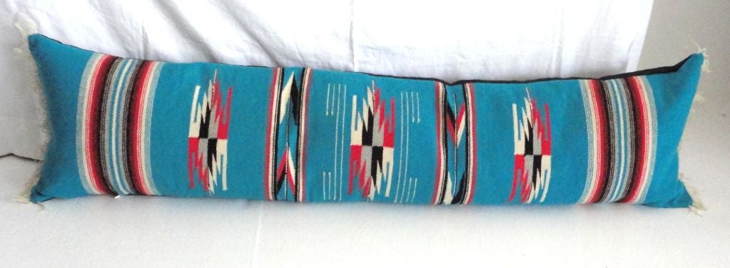 LARGE CHAMYO INDIAN WEAVING BOLSTER PILLOW IN BLUE,BLACK AND RED.THIS WONDERFUL BOLSTER IS GREAT FOR A LONG BENCH OR SOFA.GREAT CONDITION W/FRINGE AND A BLACK LINEN.