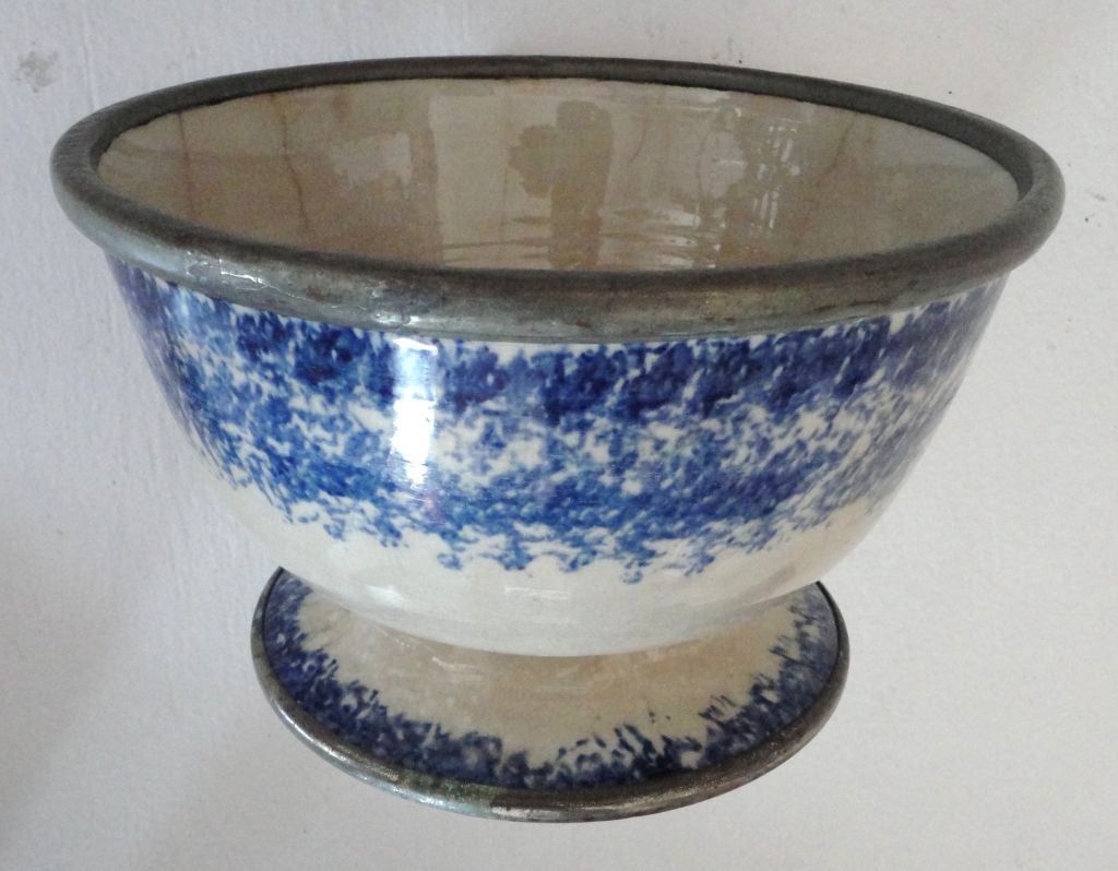 RARE AND VERY UNUSUAL 19THC  LARGE SPONGEWARE BOWL WITH METAL TRIM ON TOP AND AROUND BASE.THIS PUNCHBOWL OR LARGE SERVING BOWL HAS MINOR HAIRLINES CRACKS OR AGE CRACKS.IT IS STILL VERY SRONG AND DURABLE.THERE ARE NO CHIPS OR OTHER PIECES MISSING.
