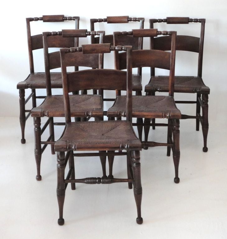19THC HITCHCOCK CHAIRS WITH ORIGINAL RUSH SEATS. REFINISHED AT ONE TIME IN A DARK  NATURAL STAIN.GREAT CONDITION AND VERY STURDY.THE HITCHCOCK CHAIRS ARE VERY HARD TO FIND IN SETS OF SIX.