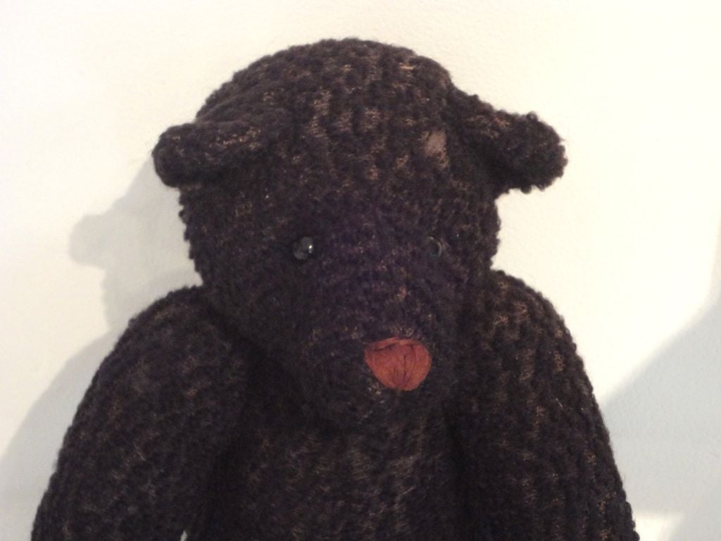 WOW THIS BEAR IS SO UNUSUAL.THE BLACK CURLY HAIR AND BLACK ROUND EYES ARE GREAT.THIS BEAR HAS LIGHT BROWN FELT REPLACED PATS AND A GROWLER IN ITS BACK THAT NO LONGER WORKS.THE CONDITION IS VERY GOOD.