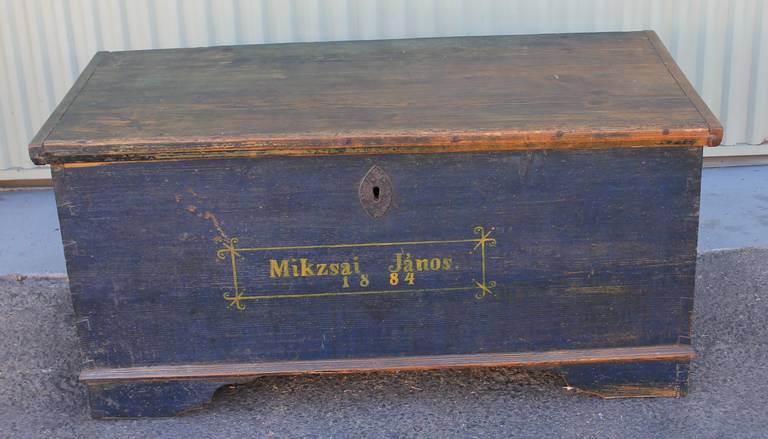 This wonderful signed and dated 1884 blanket chest is in a original blue painted surface.The dovetailed and square nailed blanket chest has a amazing untouched patina.It is from Europe and the date and name is done in a mustard yellow paint.