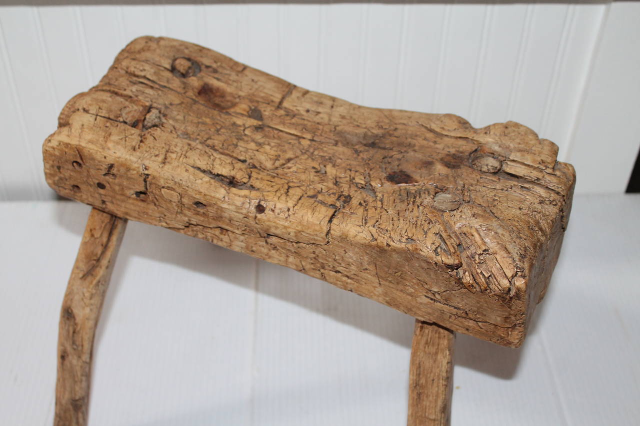 This very rustic stool has incredible patina and heavy wear consistent with age and a lot of use. This milking stool looks like it ended up being a cobblers bench. This 19th century beauty is early nail construction and all mortised legs showing