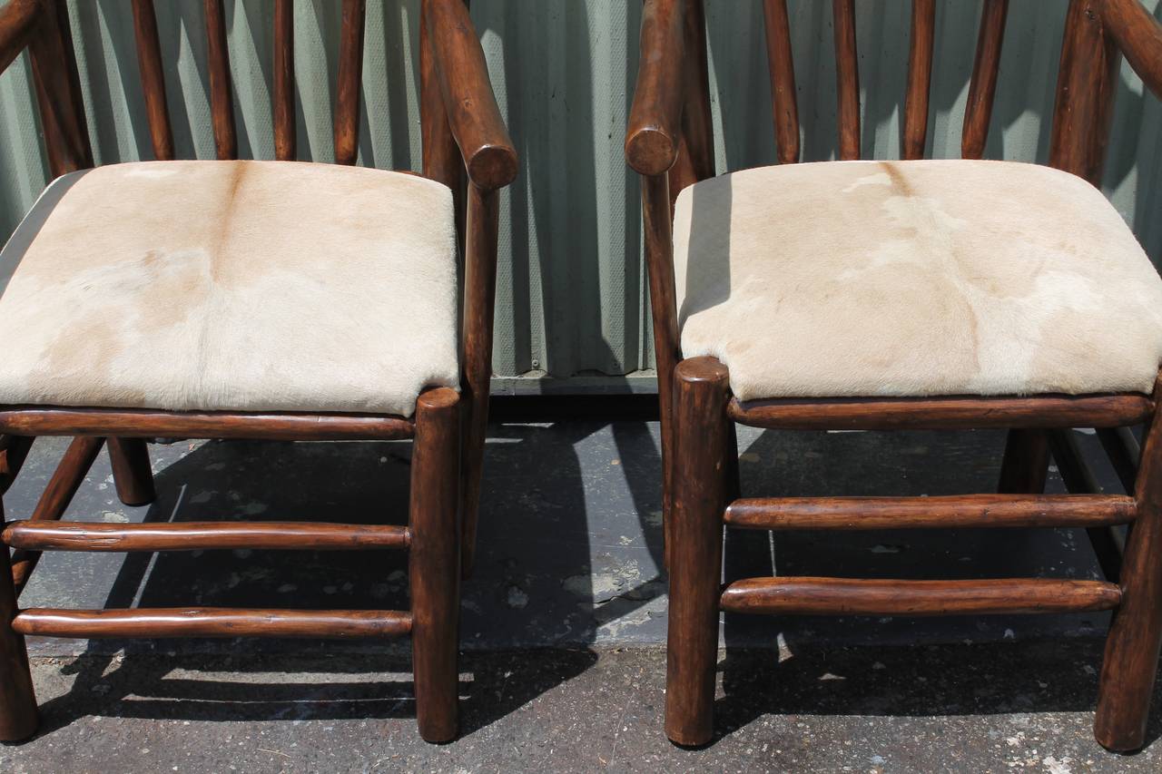 This wonderful pair of matching rustic hickory like arm chairs are in great condition and very sturdy. This pair of chairs have removable cow skin seats. The skin seat is somewhat faded or very light in color. Love them !!!